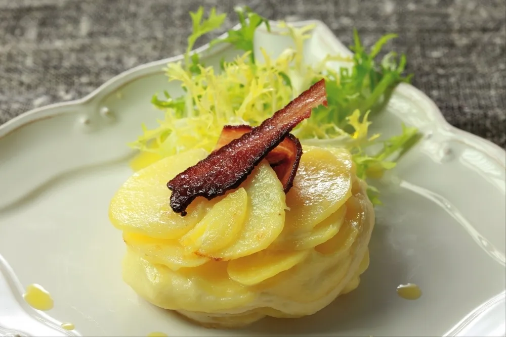 Image recette Fondant de pommes de terre et saint-marcellin, petite salade frisée et chips de lard fumé