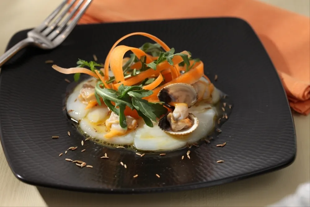 Recette Carpaccio de SaintJacques, vinaigrette au jus de coques et à l'orange