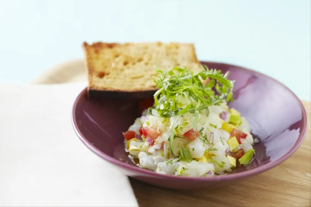 Ceviche de cabillaud, pain à l'ail et roquette