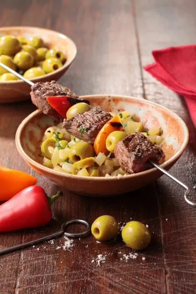 Image recette Brochettes de boeuf, condiment aux olives noires et  riviera de pommes de terre