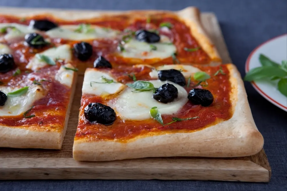 Image recette Pizza au salami, olives noires et basilic