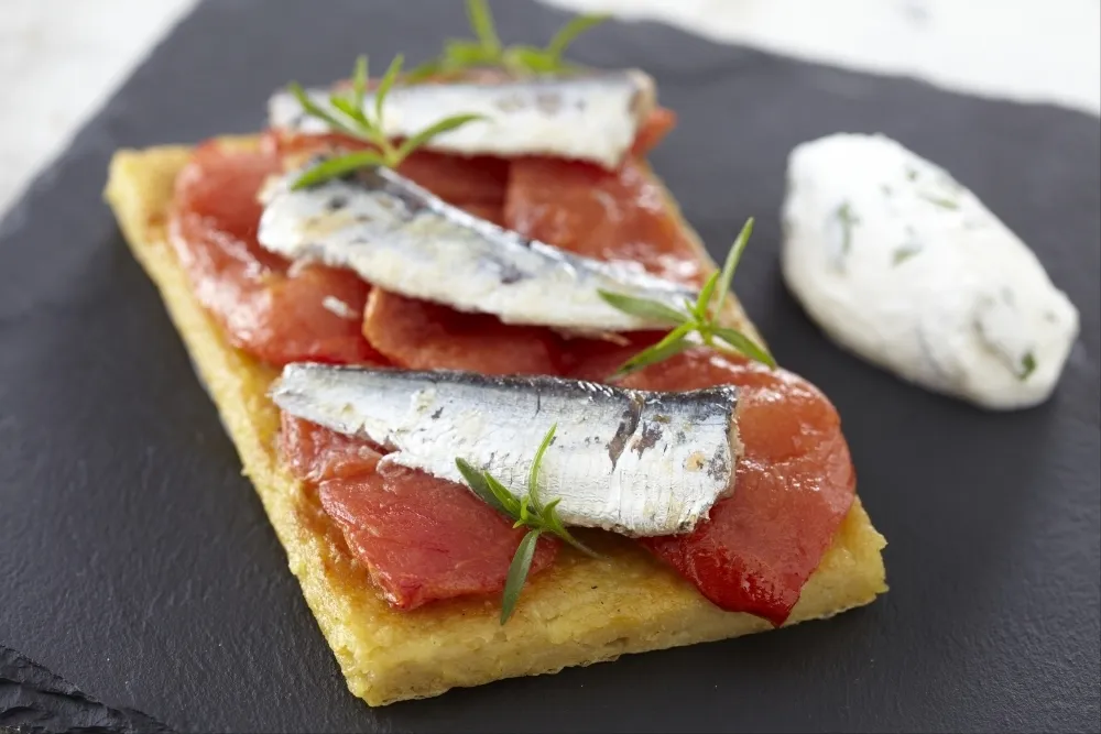 Image recette Bruschetta de panisse, sardines et tomates confites, chantilly de basilic.